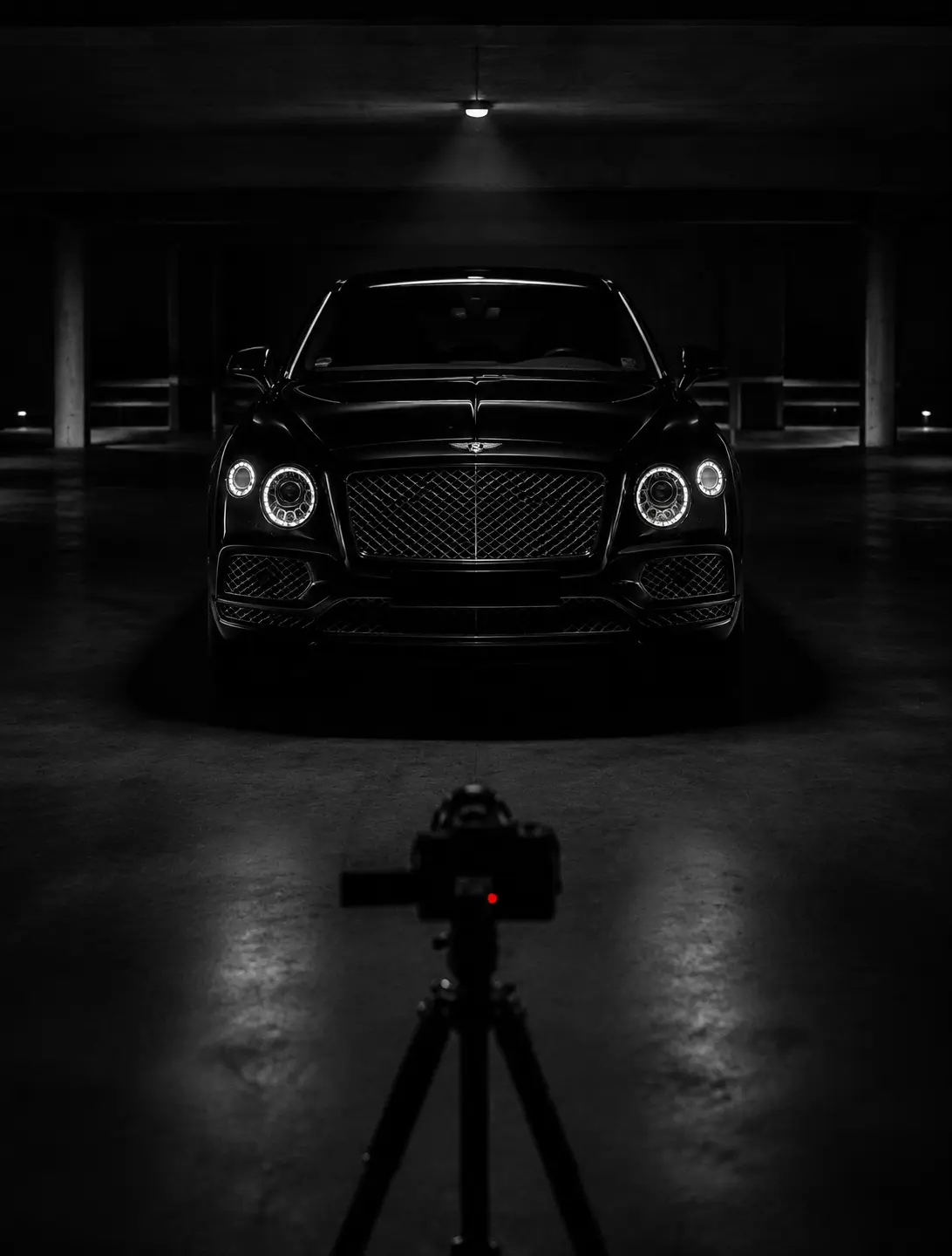 A discreet camera recording a black Bentley in a dark garage