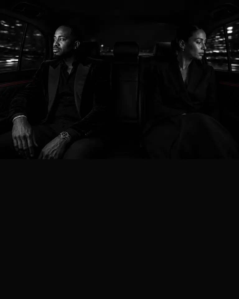 Two passengers sharing a back seat in deliberate silence at night